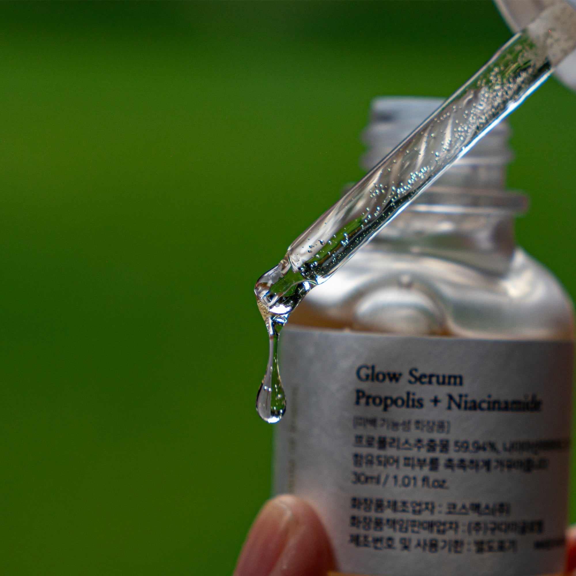 photograph of Beauty of Joseon - Glow Serum : Propolis + Niacinamide close up to the dropper dispensing a droplet of serum